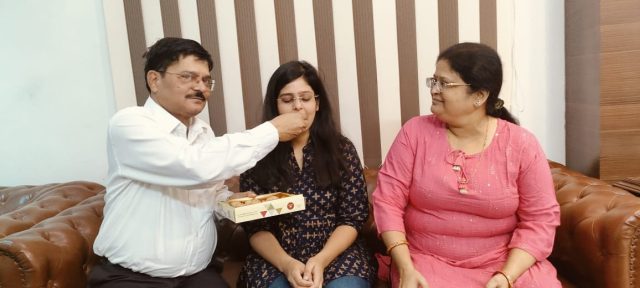अपनी बेटी की सफलता पर उसको मिठाई खिलाते डीसी शेखर जमुआर और उनकी पत्नी.